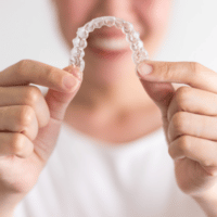 Woman holding invisalign clear aligners