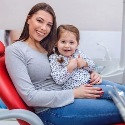 mom holding young daughter at Wake orthodontics and pediatrics bi-specialty practice
