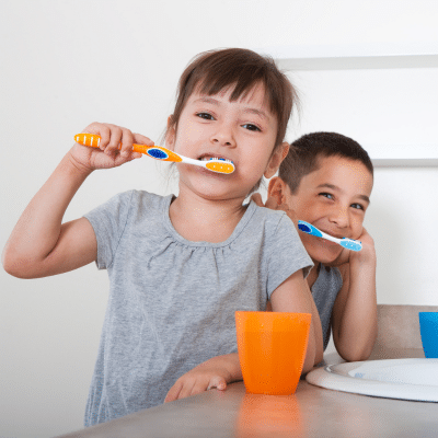 5 expert tips for instilling healthy oral habits in children 7 Two young boys brushing their teeth, practicing healthy oral habits