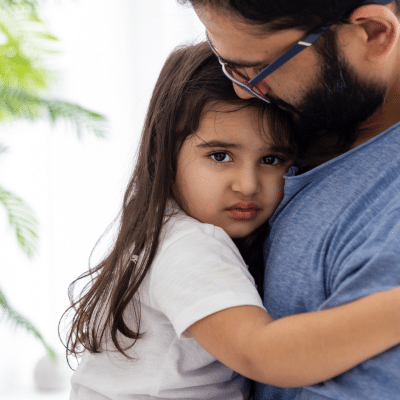 Navigating dental anxiety in children 5 Little girl holding onto her daddy, dealing with dental anxiety