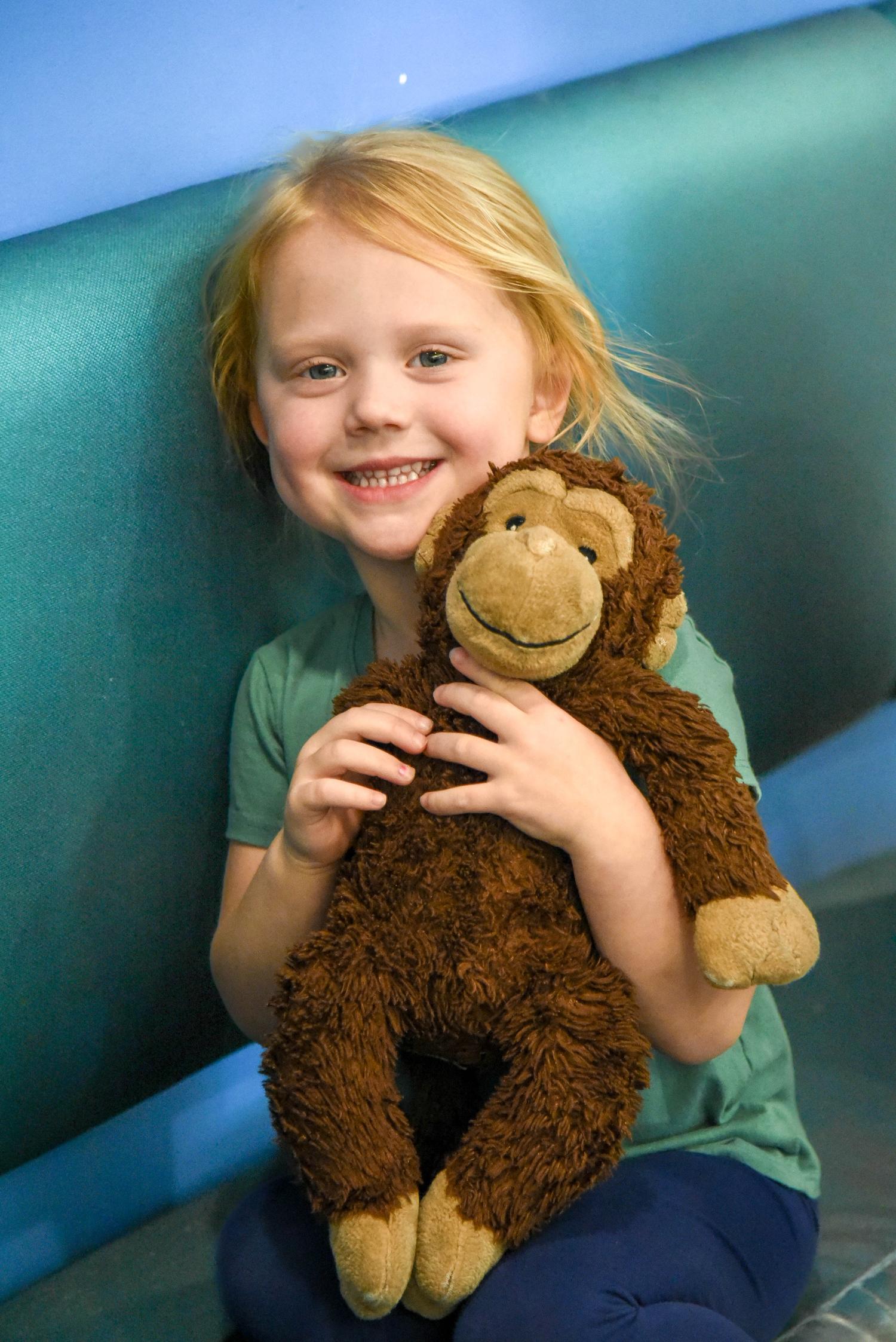 Wake pediatric patient hugging stuffed monkey