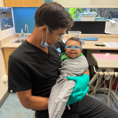 Dr. Kornstein holding a baby, representing how a tongue tie affects breastfeeding